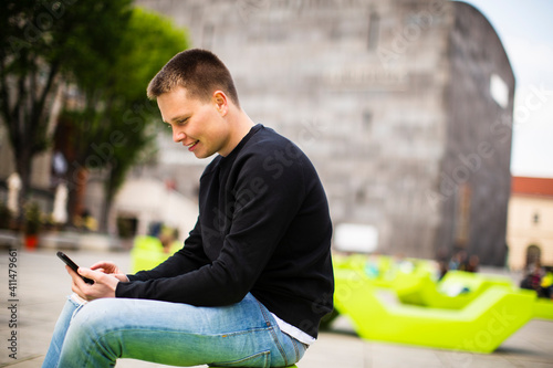Young man sitting outside a...