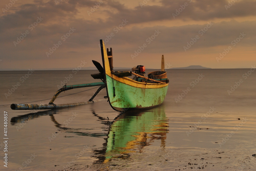 boats on the beach at sunset