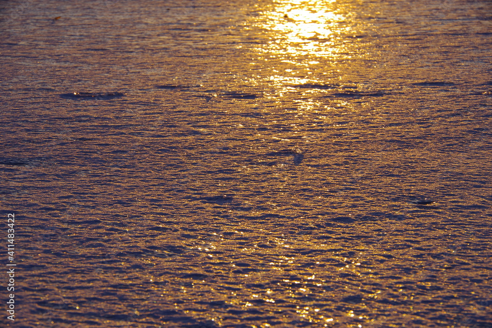 Fototapeta premium 朝陽に輝く氷に覆われた湖の表面。