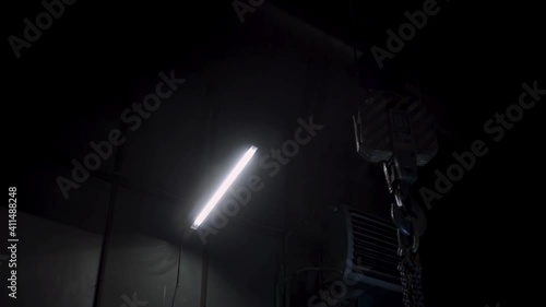 Dark photo or video studio with light spotlights and black background. Clip. Spacious dark room with shimmering light of supplied floodlights ready for professional shooting.