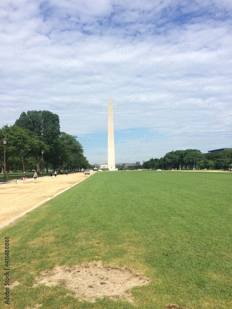 The Washington Monument between trees. It is an obelisk, made of granite and marble, within the National Mall in Washington, D.C, United States