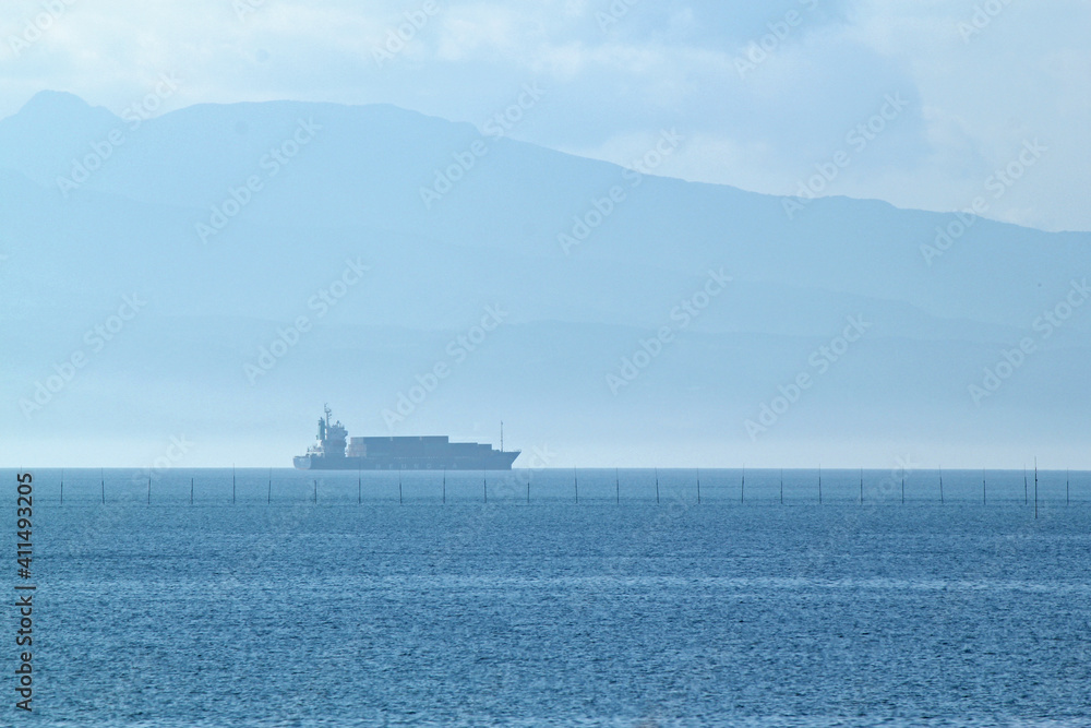 Quietly moving cargo ship and sea