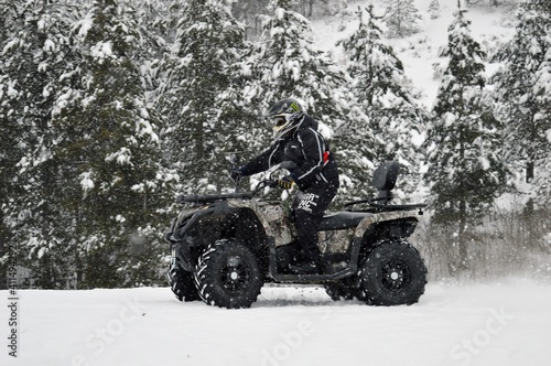 a man drive an ATV in the snow 