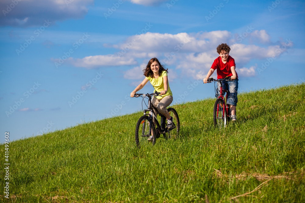 Healthy lifestyle - teenage girl and boy riding bicycles
