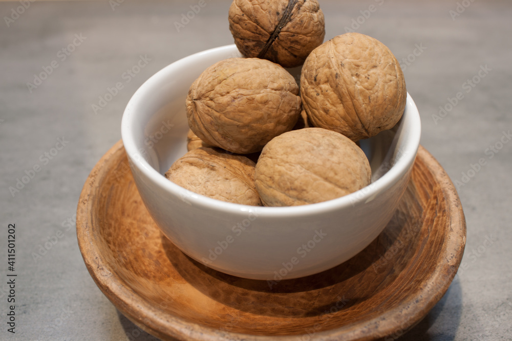 Walnuts kernels on dark desk with color background, Whole walnut in wood vintage bowl. Walnuts kernels on dark desk with color background, Whole walnut in wood vintage bowl.