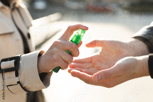 People who use alcohol-based antiseptic gel and wear a preventive mask prevent infection with the Covid-19 coronavirus outbreak, a woman washes a man's hands with hand sanitizer.