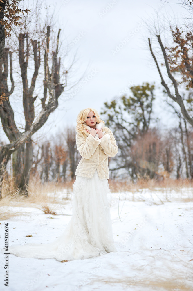 Portrait of a beautiful young woman, bride, in a winter forest Portrait of a beautiful young woman, bride, in a winter forest