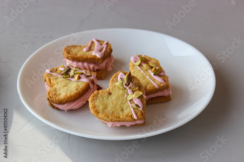 Holiday cookies in the shape of a heart, with cottage cheese cream and pistachios