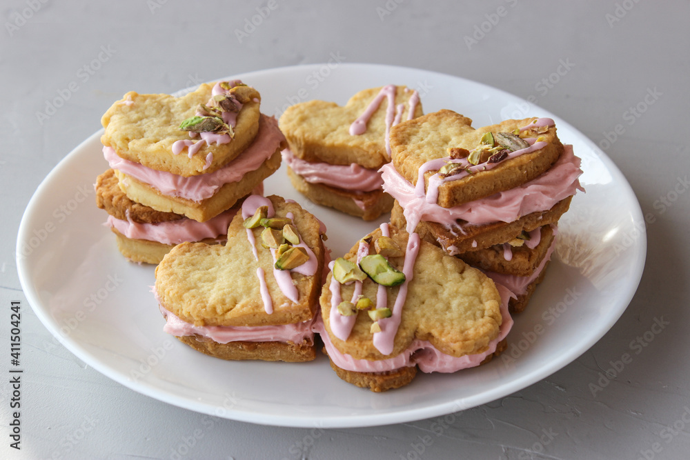 Holiday cookies in the shape of a heart, with cottage cheese cream and pistachios Holiday cookies in the shape of a heart, with cottage cheese cream and pistachios