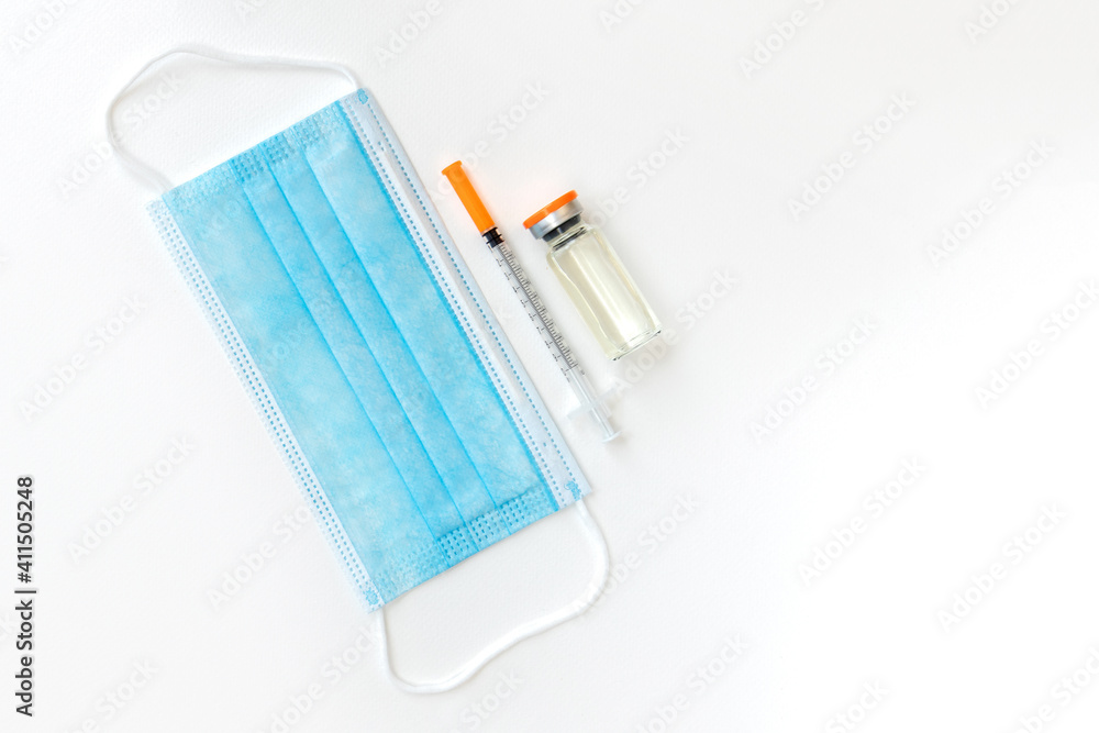 Vaccine vial, syringes and surgical mask isolated on white background, flat lay with space for text. Vaccination and immunization Vaccine vial, syringes and surgical mask isolated on white background, flat lay with space for text. Vaccination and immunization
