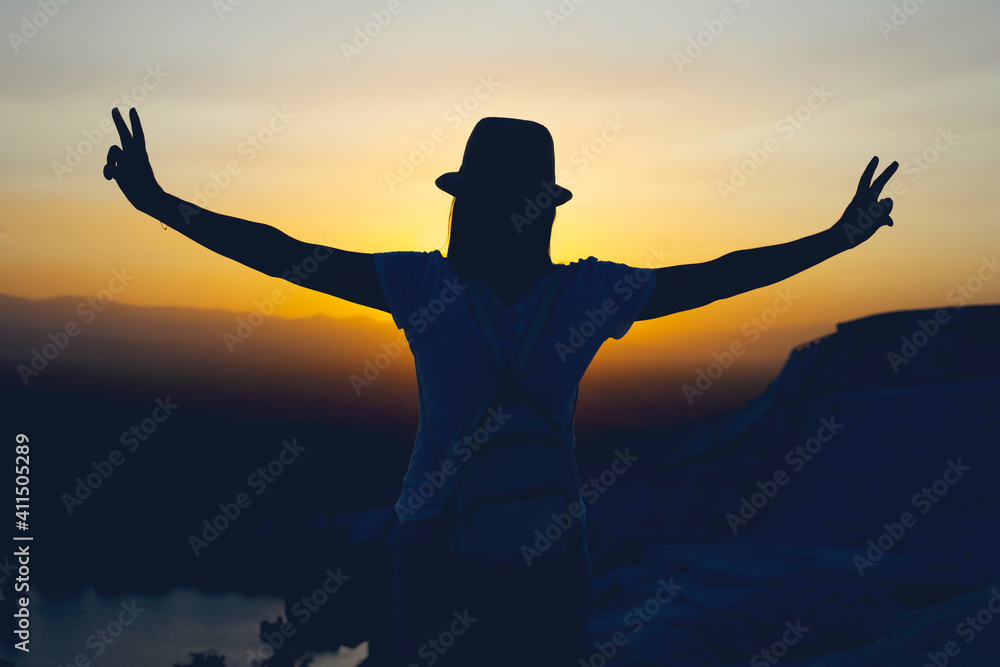 Silhouette of two fingers of woman hand or victory in front of the sun during sunset time. Fighting concept