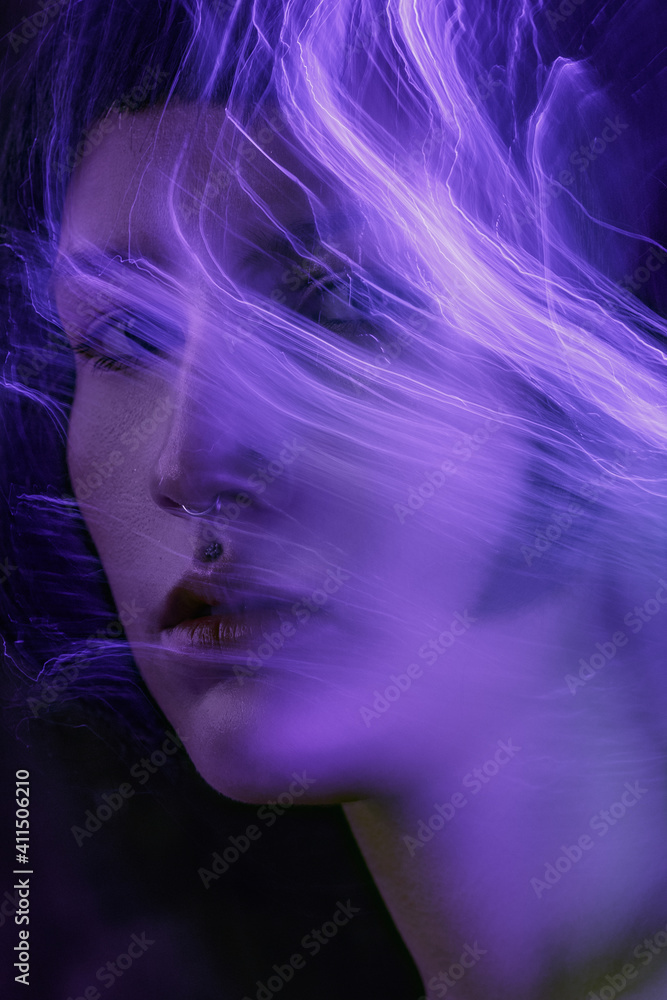 a mystical futuristic portrait of a girl with an experimental neon light. light abstract lines, lightning electricity on the face. achromatic with distorted makeup.