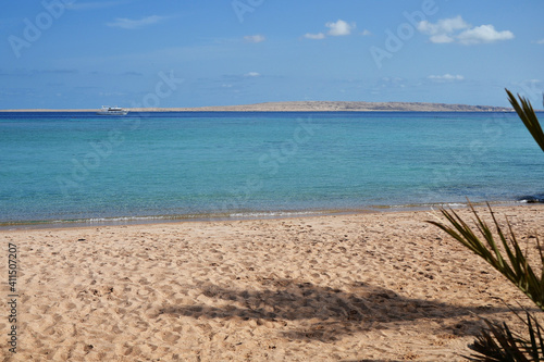 Sandy beach, sea and blue sky with clouds photo