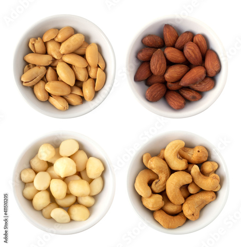 Nuts in circle shaped ceramic bowls isolated on white background. Various nuts (almonds, macadamia, cashew, peanuts). Mix nut  healthy ingredients food.