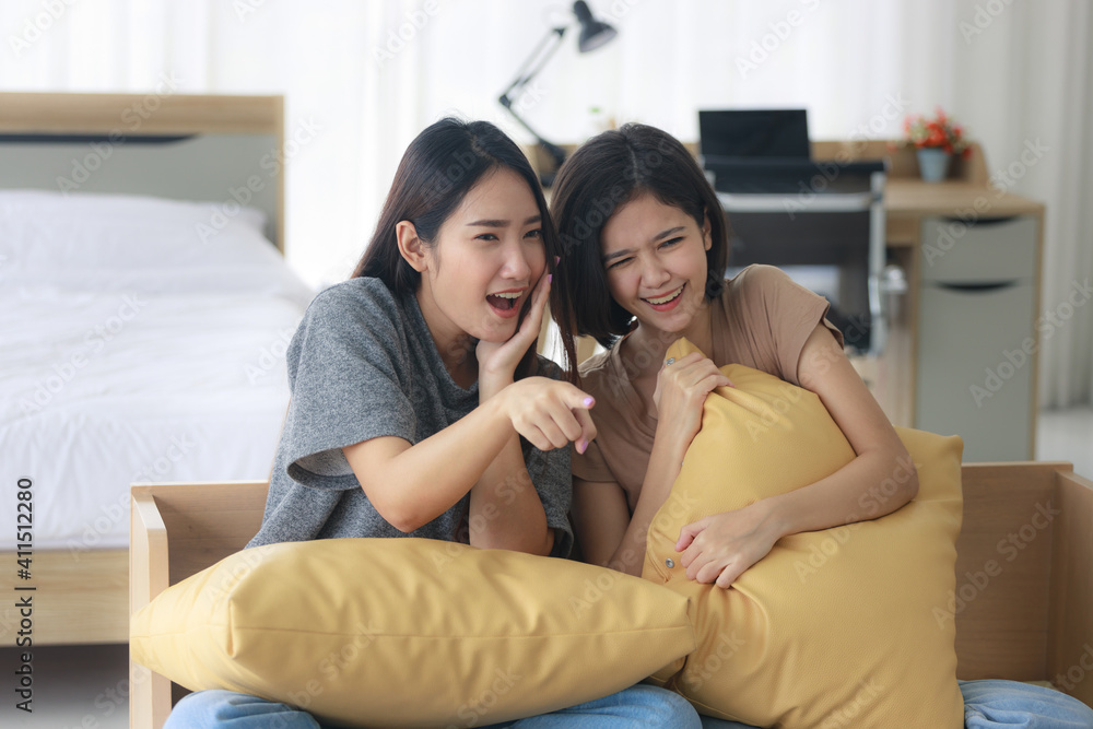 Two Asian teenage girls are Intimate friends with short and long hair they are happy to watch movies and series on TV in the bedroom. Young women are enjoying leisure activities. Two Asian teenage girls are Intimate friends with short and long hair they are happy to watch movies and series on TV in the bedroom. Young women are enjoying leisure activities.