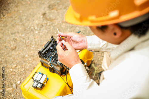 Fiber Optic Fusion Splicing Cable checking signal and Wire connection with Fiber Optic Fusion Splicing machine.The technician is checking the fiber optic cable