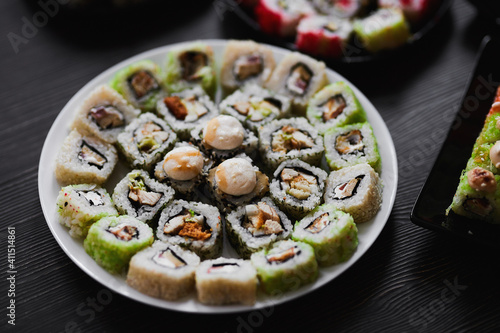 Fresh sushi rolls set on gark background photo