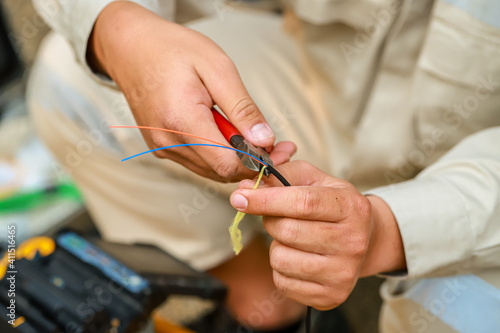 Fiber Optic Fusion Splicing Cable checking signal and Wire connection with Fiber Optic Fusion Splicing machine.The technician is checking the fiber optic cable