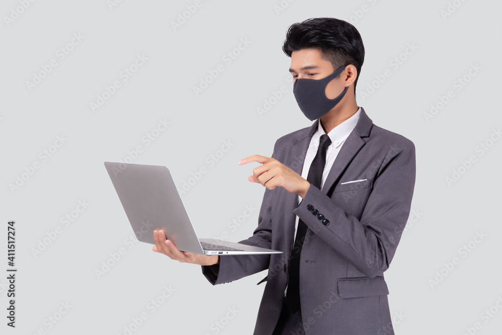 Young asian business man in face mask using laptop computer isolated on white background, quarantine and epidemic covid-19, businessman work from home for health, social distancing, new normal. Young asian business man in face mask using laptop computer isolated on white background, quarantine and epidemic covid-19, businessman work from home for health, social distancing, new normal.