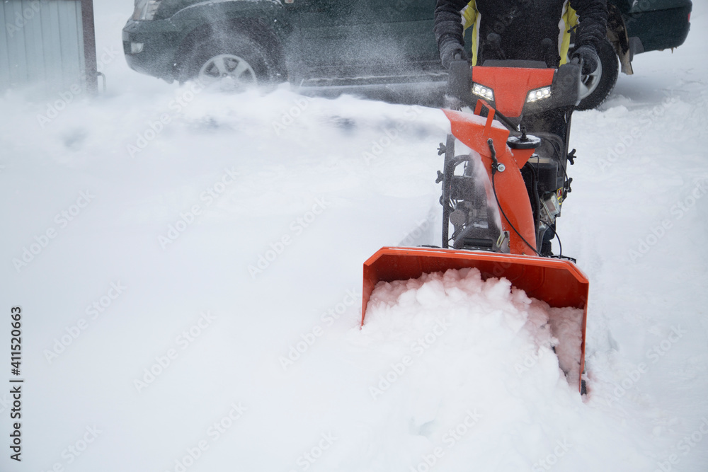 A portable snow blower powered by gasoline. Snow removal in winter. A portable snow blower powered by gasoline. Snow removal in winter.