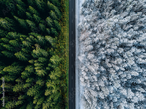Aerial view of a highway road through the forest in summer and winter.