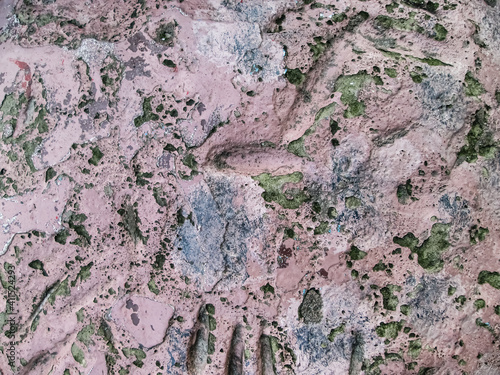 Abstract pale pink background with damages. Destroyed old paint on battered concrete.