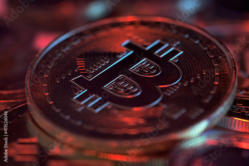 Macro Shot of Cyrpto Currency Bitcoin Under Colourful Lights. Some Coins Out of Focus on Background. Block Chain Technology. New Era of Digital Banking, Finance and E-Commerce.