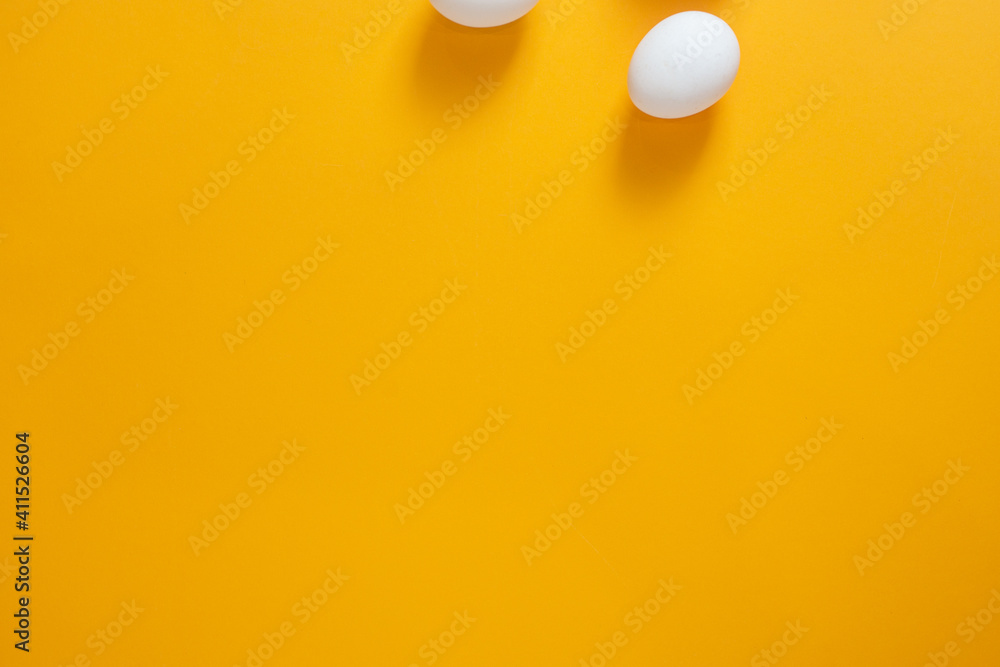 Chicken white eggs on a yellow background.