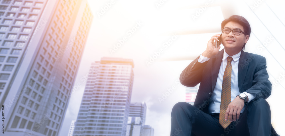 Asian business man using mobile phone outdoor with blurred background. Panoramic banner of information and multimedia technology Asian business man using mobile phone outdoor with blurred background. Panoramic banner of information and multimedia technology