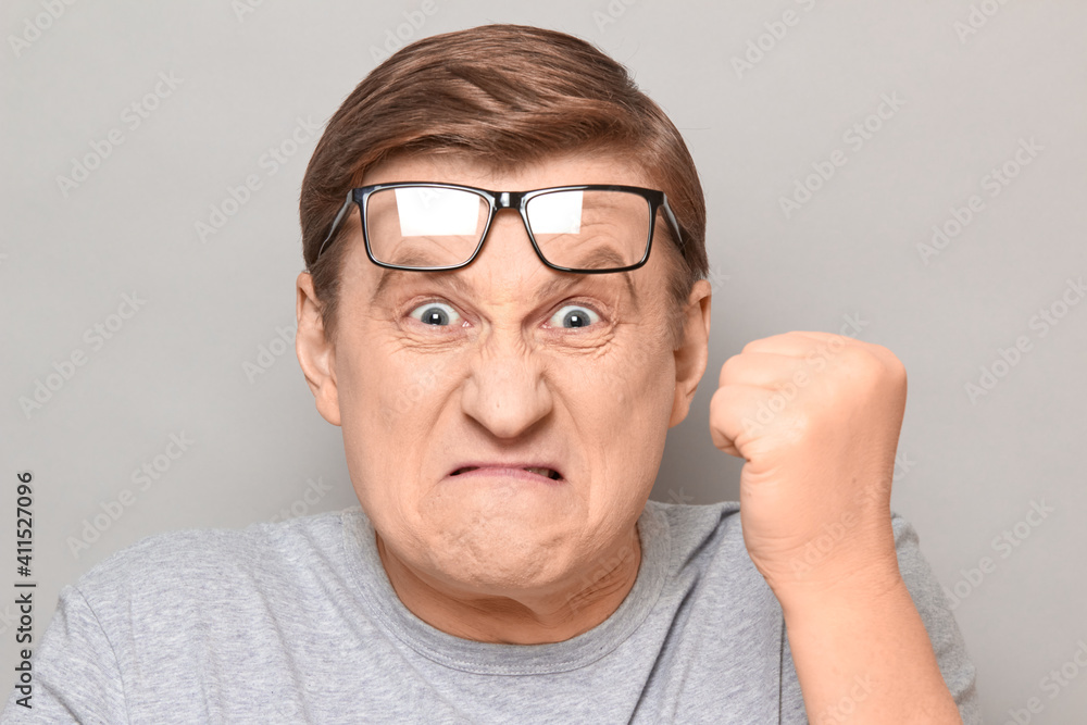 Portrait of angry annoyed man shaking fist in threatening gesture Portrait of angry annoyed man shaking fist in threatening gesture