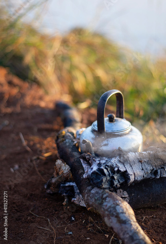 The picture of the kettle in the outdoor location that is camping according to the natural location.