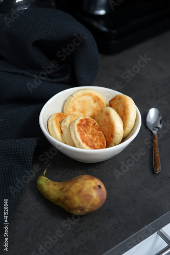 A bowl of homemade cheesecakes on a black table in the kitchen