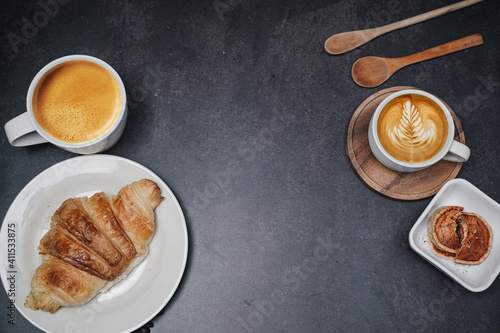 cup of coffee and Fresh baked croissant on old kitchen table. Top view with copyspace for your text.