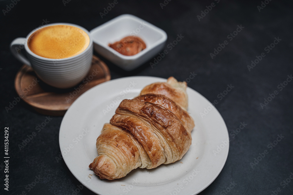 cup of coffee and Fresh baked croissant on old kitchen table. Top view with copyspace for your text.