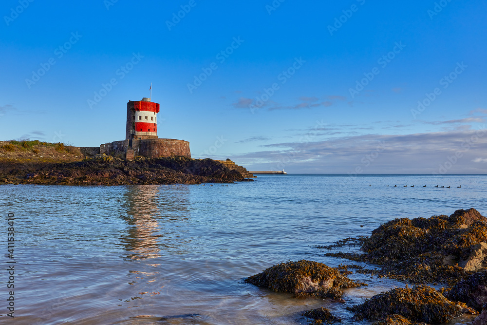 Image of Archirondel Bay with the Napoleonic Jersey Tower early on a sunny day, with St Caherines Breakwater in the far back ground.. Jersey, Channel Islands