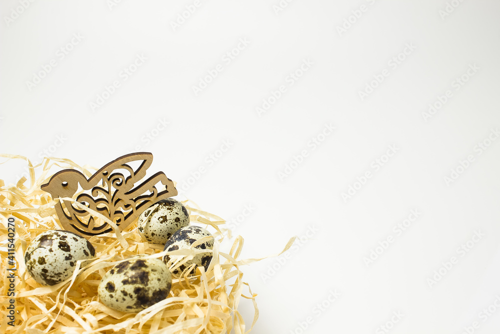 Naklejka premium beige nest of a wooden bird made of paper shavings with quail eggs on a white background with a place for text and inscriptions.
