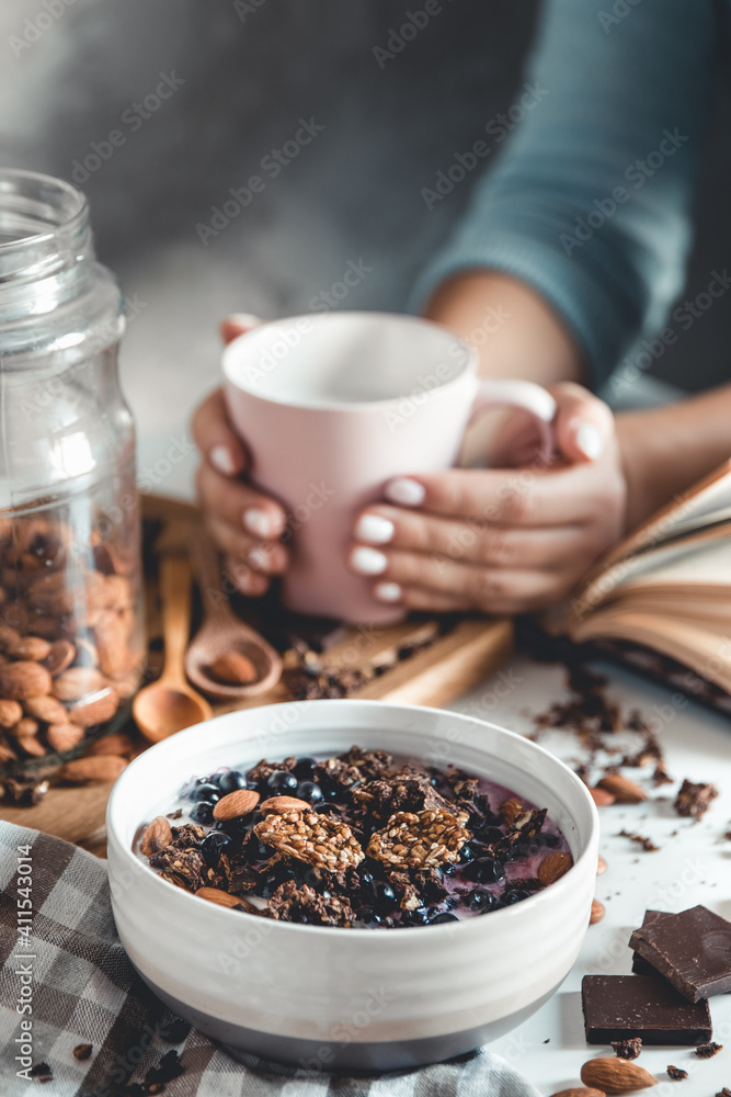 Healthy breakfast, muesli with berries and orange juice served on glass table and books. manicure Healthy breakfast, muesli with berries and orange juice served on glass table and books. manicure