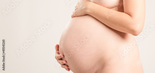 Wallpaper Mural Cute pregnant belly isolated on white. Side view of young pregnant woman embracing her naked abdomen with hands.  Concept woman pregnant life. Torontodigital.ca