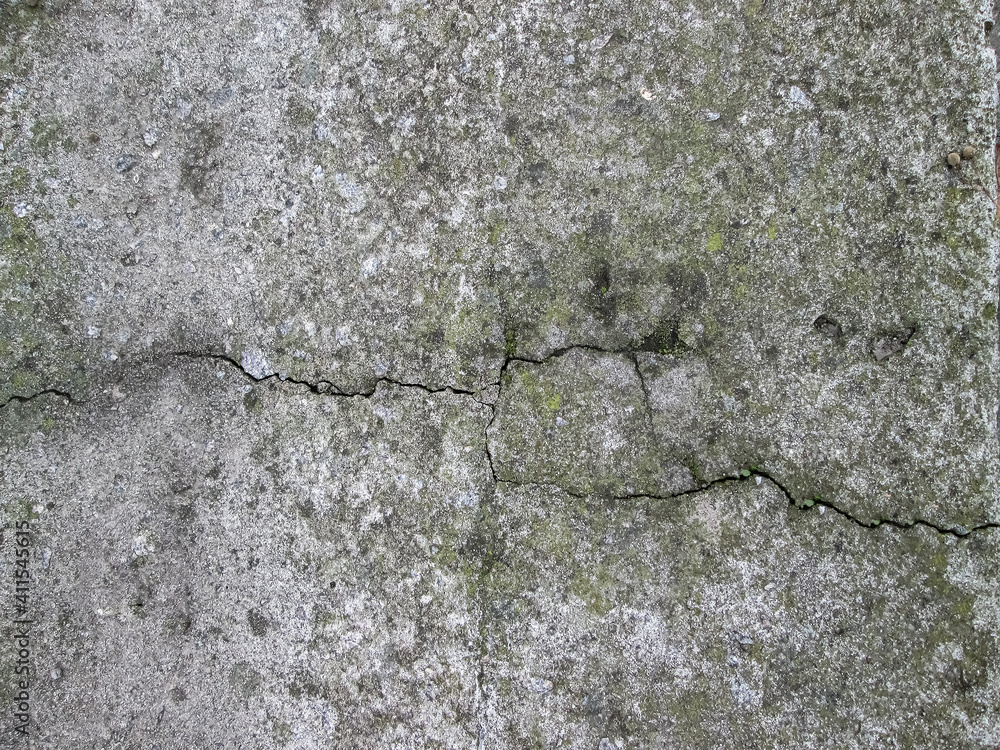 A crack in the stone. Monotone concrete slab with grit and streaks. Concrete wall texture with rough edges. A crack in the stone. Monotone concrete slab with grit and streaks. Concrete wall texture with rough edges.