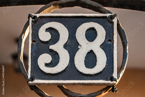 Old retro weathered cast iron plate with number 38 closeup photo