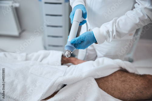 Doctor using modern machine for treating man