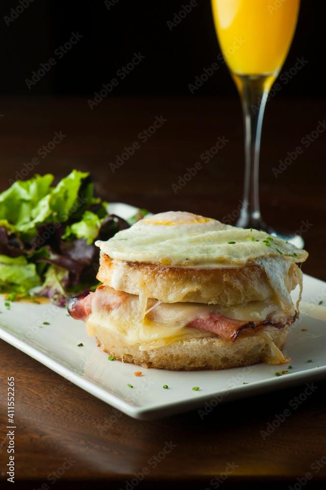 Croque madame or monsieur. Breakfast or brunch favorite: toast, with fried eggs, ham, cheese, and hollandaise sauce. Served with potato hash. Classic French bistro or American restaurant entree. Croque madame or monsieur. Breakfast or brunch favorite: toast, with fried eggs, ham, cheese, and hollandaise sauce. Served with potato hash. Classic French bistro or American restaurant entree.