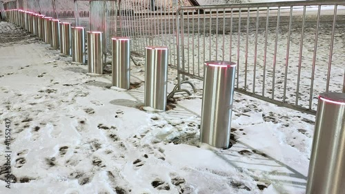 View of an automatic cylindrical fence that blocks the path of cars and people. photo