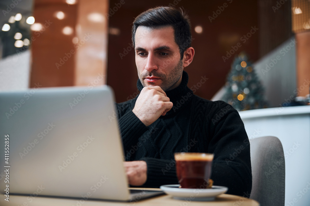 Businessman spending Christmas Eve with laptop in hotel