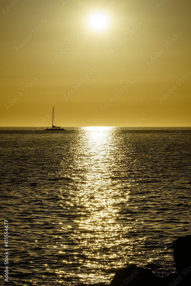 sunset in the sea with the sun on the horizon reflecting the light in the water and on the rocks on the shore. Gran Canaria. Spain. sunset in the sea with the sun on the horizon reflecting the light in the water and on the rocks on the shore. Gran Canaria. Spain.
