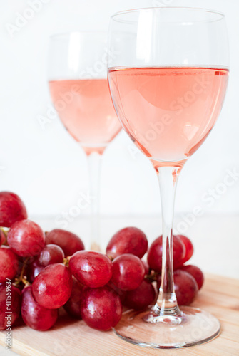 Glasses of rose wine and red grapes on white background. two glasses of champagne