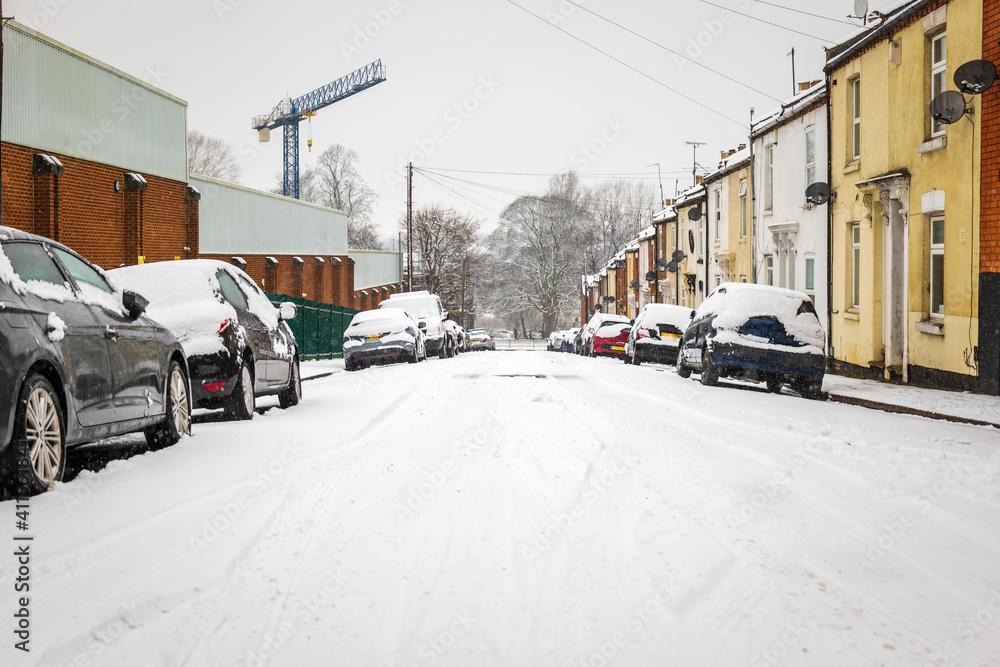 Fototapeta premium Car parked on british street under winter snow fall in england uk
