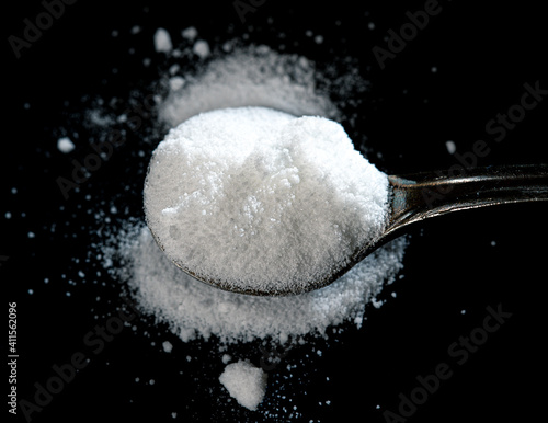 selective focus photo of citrulline malate in an iron spoon. dietary concept. dietary supplement low-key photo.
