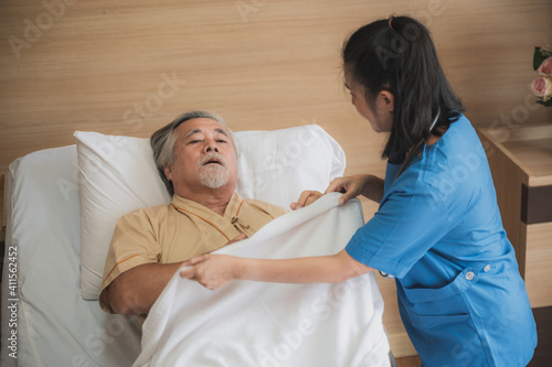 Nurses support the elderly patient man to resting at hospital room, medical health care and old disease insurance concept