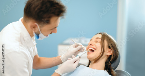Young patient during a dental checkup. Dentist examining teeth of a woman at the dental office. 4k video screenshot, please use in small size